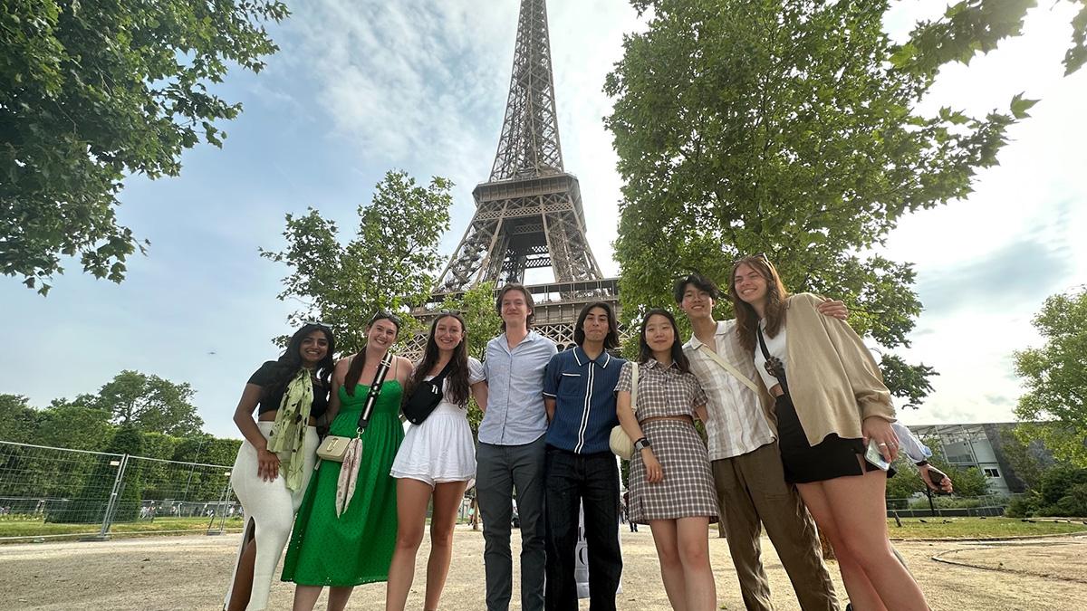 Several students pose in front of the Eiffel Tower.