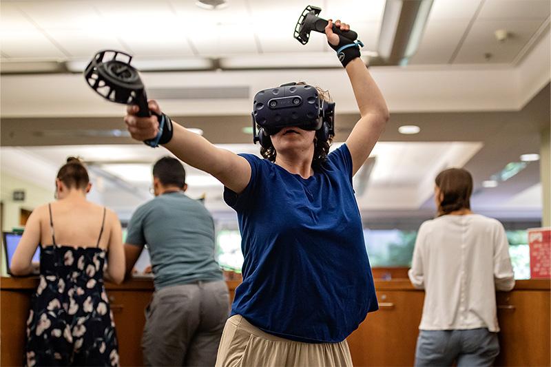 A student using a VR headset 和 h和held devices in the Undergraduate Library on the campus of UNC-Chapel Hill.