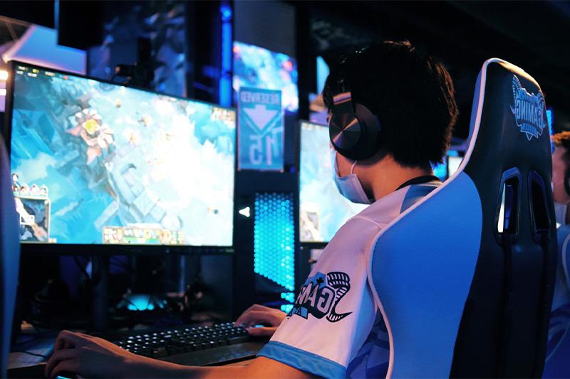 A student sitting in front of a monitor 和 keyboard in an on-campus e-sports arena at UNC-Chapel Hill