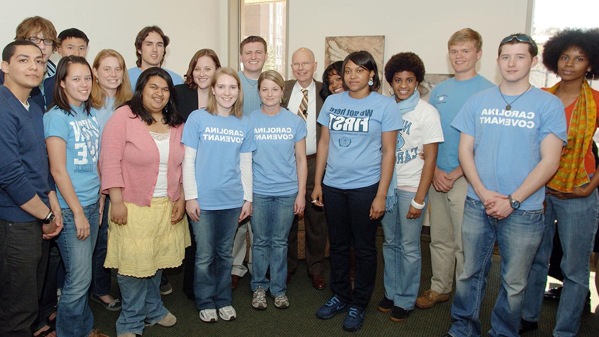 一群卡罗来纳州的学生, who are 卡约 Scholars, in 2004 posing for a group photo with Chancellor James Moeser.